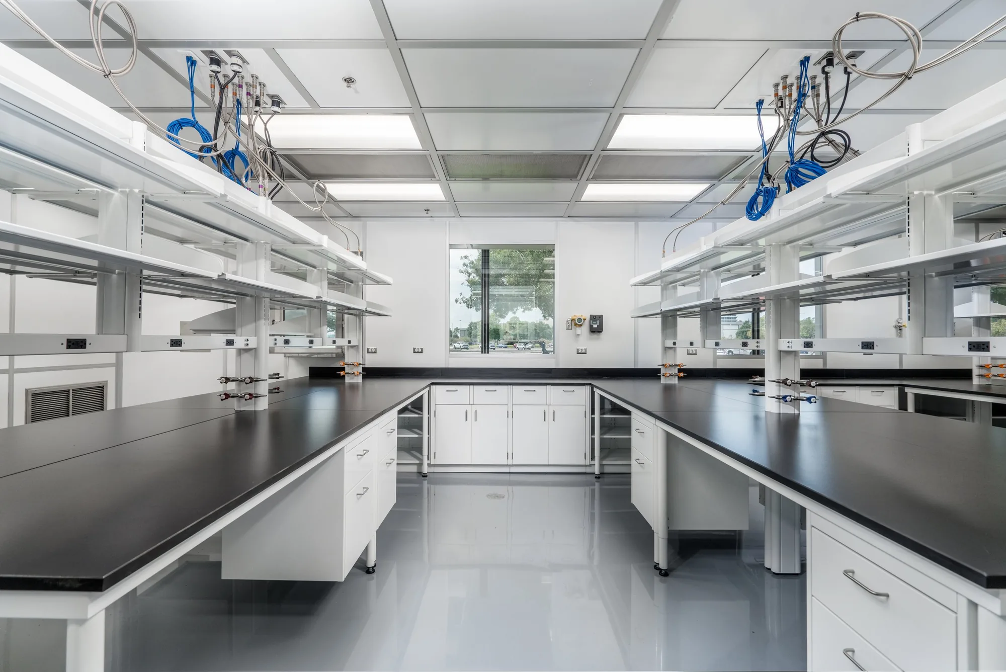 Building 31 clean room looking toward the window, with facing lab benches and service columns.